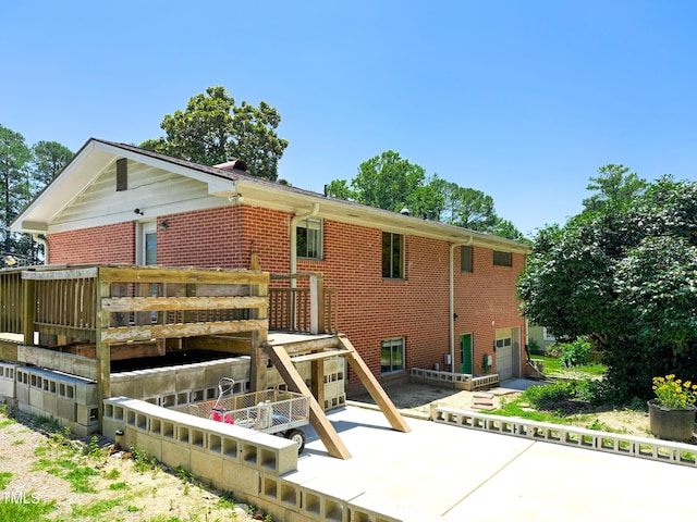 3323 Baugh St, Raleigh, NC 27604 - rear view of property featuring brick siding, an attached garage, and a patio area
