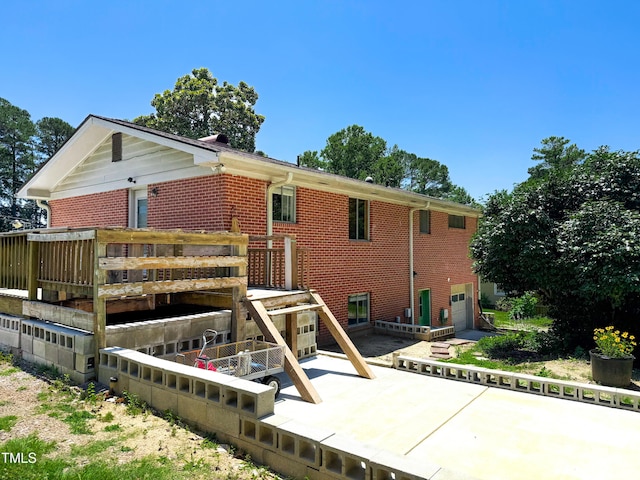3323 Baugh St, Raleigh, NC 27604 - back of house featuring brick siding, a garage, and a patio area