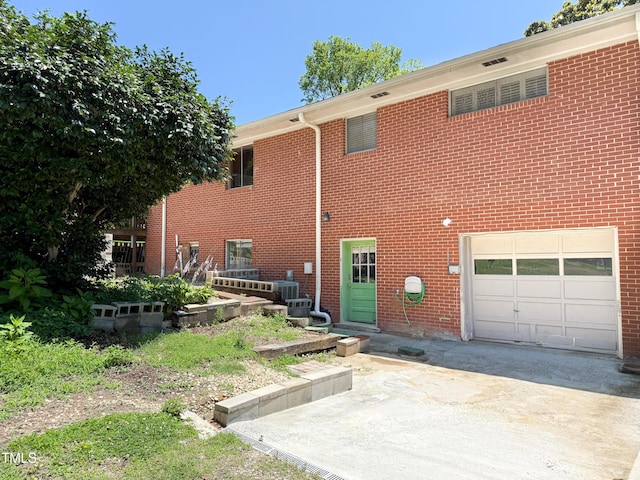 3323 Baugh St, Raleigh, NC 27604 - rear view of house with an attached garage, concrete driveway, and brick siding