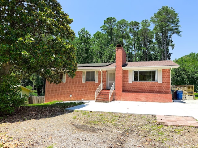 3323 Baugh St, Raleigh, NC 27604 - ranch-style home with solar panels, brick siding, a chimney, and a patio area