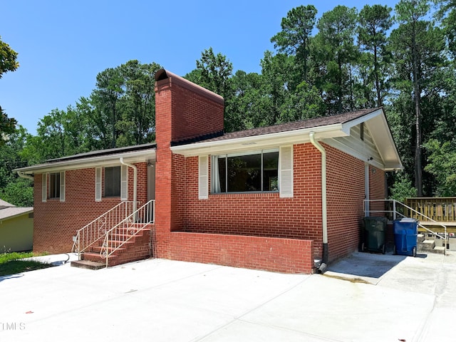 3323 Baugh St, Raleigh, NC 27604 - view of front of property with a chimney, a patio, and brick siding