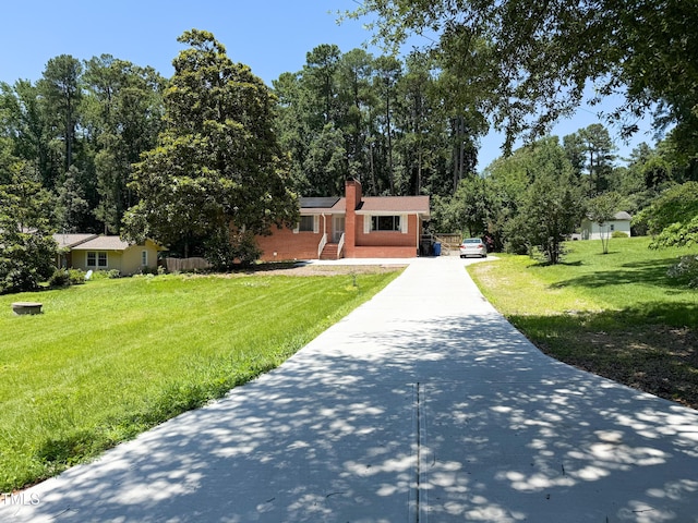 3323 Baugh St, Raleigh, NC 27604 - view of front of home with driveway, a chimney, a front lawn, and brick siding