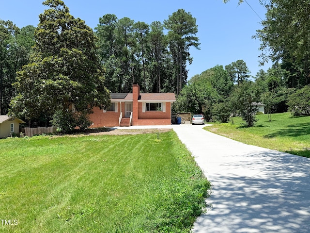 3323 Baugh St, Raleigh, NC 27604 - single story home featuring concrete driveway, a front lawn, a chimney, brick siding, and solar panels