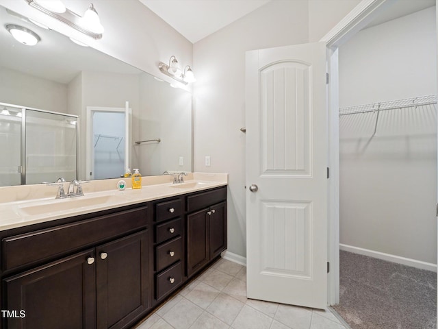 115 Snowy Orchid Ln, Smithfield, NC 27577 - bathroom with a walk in closet, double vanity, a shower stall, tile patterned flooring, and lofted ceiling