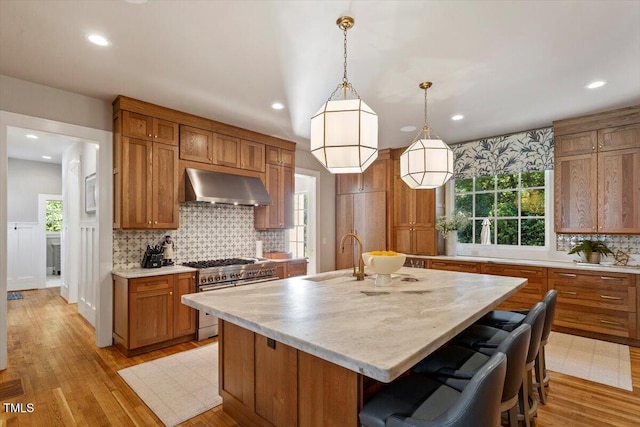 1054 Canterbury Ln, Chapel Hill, NC 27517 - kitchen featuring double oven range, ventilation hood, light countertops, decorative backsplash, and brown cabinetry