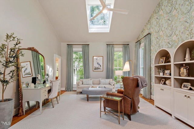 1054 Canterbury Ln, Chapel Hill, NC 27517 - living room with high vaulted ceiling, ceiling fan, a skylight, wallpapered walls, and light wood-type flooring