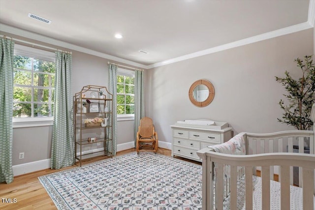 1054 Canterbury Ln, Chapel Hill, NC 27517 - bedroom with wood finished floors, a crib, and crown molding