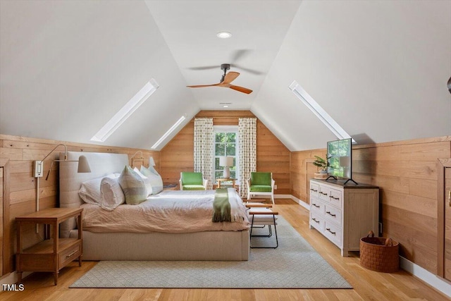 1054 Canterbury Ln, Chapel Hill, NC 27517 - bedroom featuring light wood-style floors, wooden walls, vaulted ceiling, a skylight, and ceiling fan