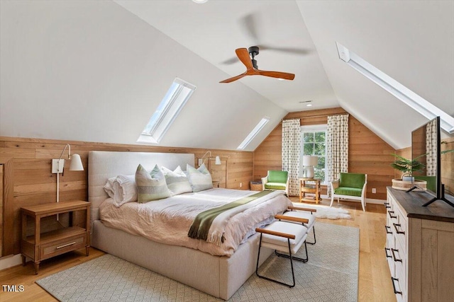 1054 Canterbury Ln, Chapel Hill, NC 27517 - bedroom with light wood finished floors, wooden walls, a skylight, and vaulted ceiling