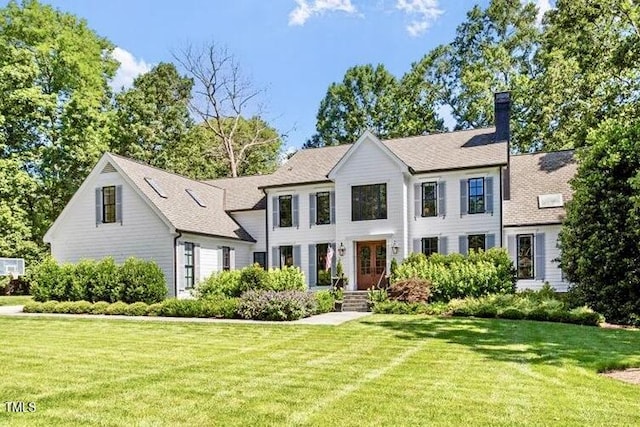 1054 Canterbury Ln, Chapel Hill, NC 27517 - view of front facade with a front lawn, a chimney, and roof with shingles