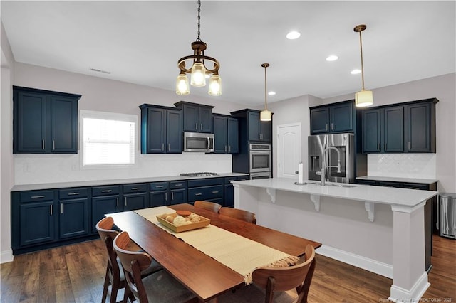 116 School Side Dr, Spring Lake, NC 28390 - kitchen featuring appliances with stainless steel finishes, dark wood-style flooring, light countertops, decorative backsplash, and a breakfast bar