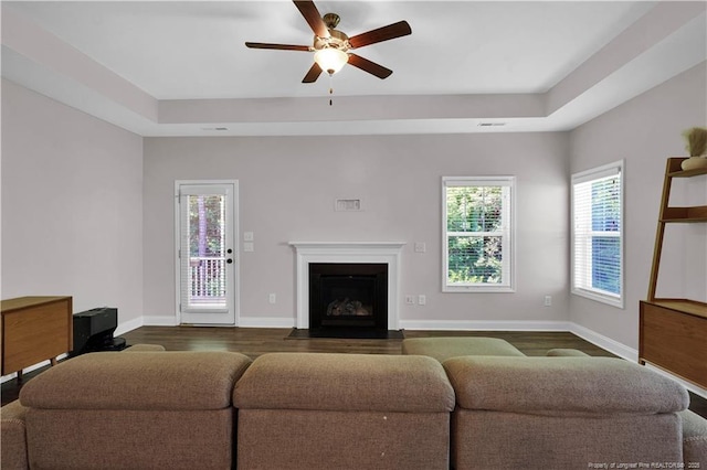 116 School Side Dr, Spring Lake, NC 28390 - living area featuring dark wood-type flooring, a raised ceiling, ceiling fan, and a fireplace with flush hearth
