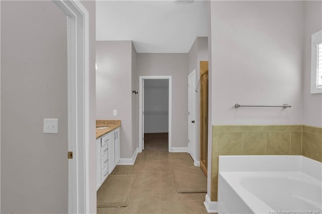 116 School Side Dr, Spring Lake, NC 28390 - full bath featuring a garden tub, a shower stall, a walk in closet, vanity, and tile patterned flooring