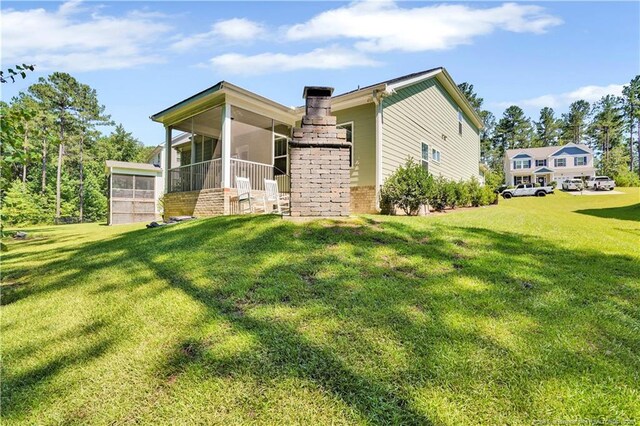116 School Side Dr, Spring Lake, NC 28390 - back of property with a sunroom, a lawn, and brick siding