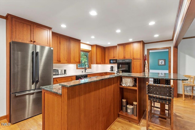 701 Bennington Dr, Raleigh, NC 27615 - kitchen with black appliances, ornamental molding, brown cabinets, light wood-style floors, and dark stone countertops