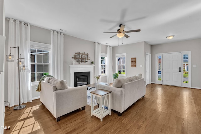 3119 Guiding Light Rd, Raleigh, NC 27610 - living area featuring a ceiling fan, a glass covered fireplace, and wood finished floors