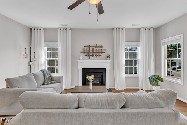 3119 Guiding Light Rd, Raleigh, NC 27610 - living room featuring a fireplace with flush hearth, a ceiling fan, and wood finished floors
