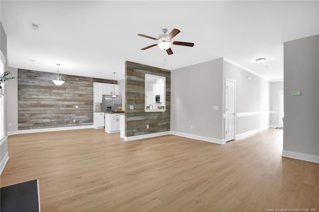 786 Century Dr, Cameron, NC 28326 - unfurnished living room with ceiling fan, wood walls, an accent wall, and light wood finished floors