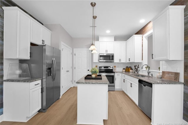 786 Century Dr, Cameron, NC 28326 - kitchen featuring stainless steel appliances, a kitchen island, light wood-style flooring, dark stone counters, and recessed lighting