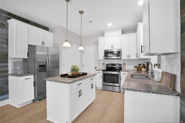 786 Century Dr, Cameron, NC 28326 - kitchen featuring appliances with stainless steel finishes, a kitchen island, light wood-style floors, backsplash, and recessed lighting