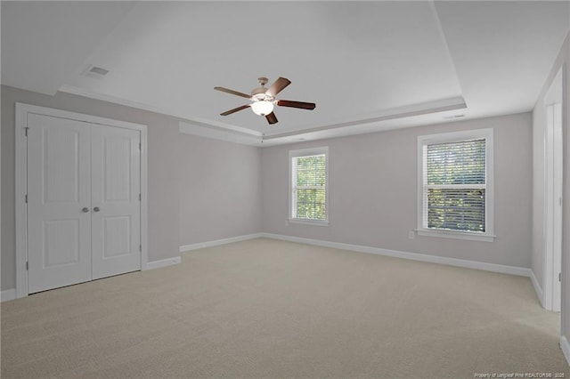786 Century Dr, Cameron, NC 28326 - unfurnished bedroom featuring light carpet, a raised ceiling, and multiple windows
