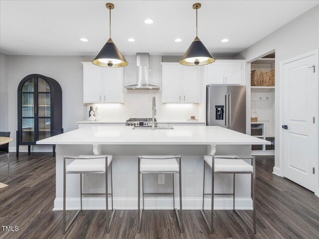 128 Chapel Run Way, Chapel Hill, NC 27517 - kitchen with wall chimney exhaust hood, high end refrigerator, dark wood-style flooring, an island with sink, and recessed lighting