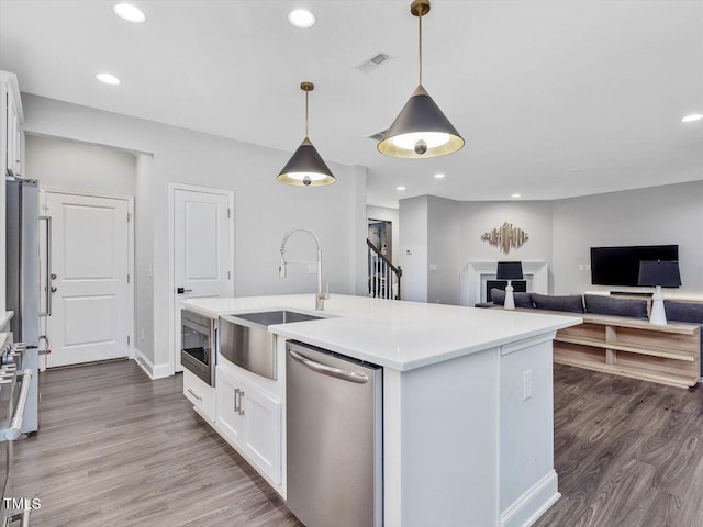 128 Chapel Run Way, Chapel Hill, NC 27517 - kitchen featuring stainless steel appliances, white cabinetry, wood finished floors, light countertops, and pendant lighting