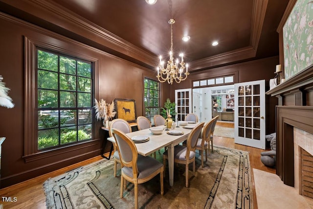 2602 Vintage Hill Ct, Durham, NC 27712 - dining room featuring ornamental molding, a chandelier, wood finished floors, a tray ceiling, and a fireplace