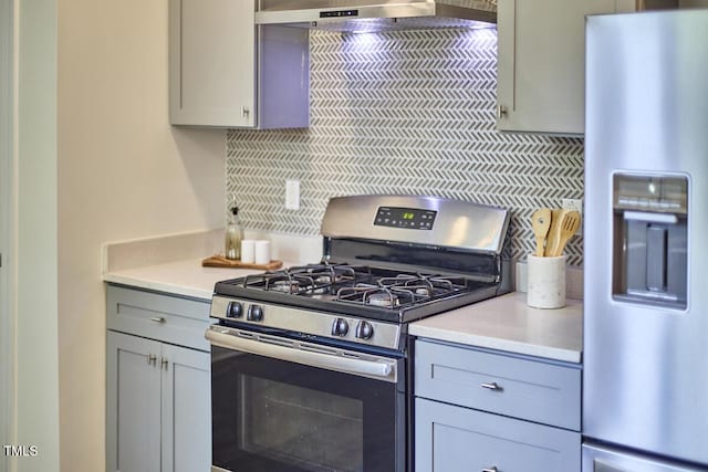 931 Ramseur St, Durham, NC 27701 - kitchen with appliances with stainless steel finishes, gray cabinets, backsplash, light countertops, and exhaust hood
