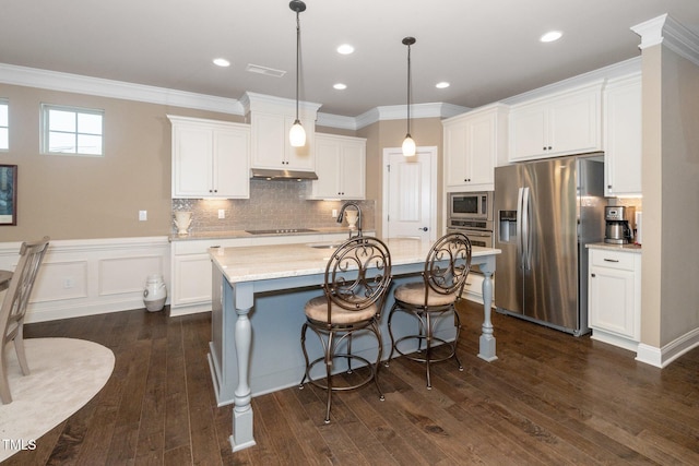 1409 Pulitzer Ln, Durham, NC 27703 - kitchen featuring appliances with stainless steel finishes, under cabinet range hood, white cabinetry, dark wood finished floors, and crown molding