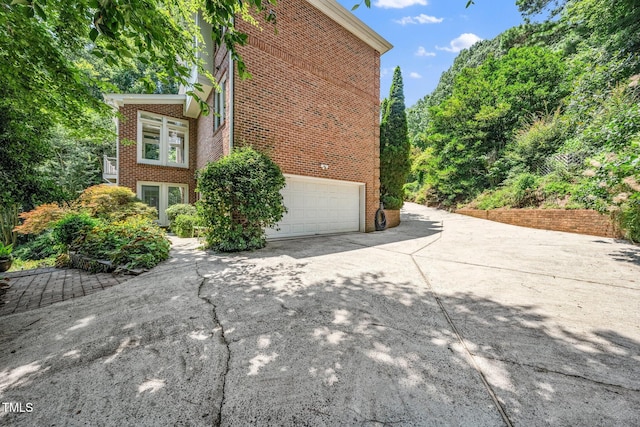 115 Loch Vale Ln, Cary, NC 27518 - view of property exterior featuring brick siding, concrete driveway, and an attached garage