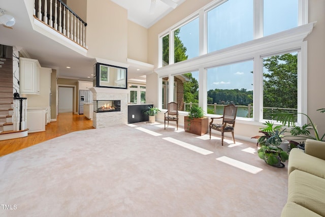 115 Loch Vale Ln, Cary, NC 27518 - living room with ornamental molding, plenty of natural light, a multi sided fireplace, a towering ceiling, and light wood-style floors