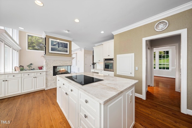 115 Loch Vale Ln, Cary, NC 27518 - kitchen featuring black electric stovetop, stainless steel oven, light wood-style flooring, healthy amount of natural light, and crown molding