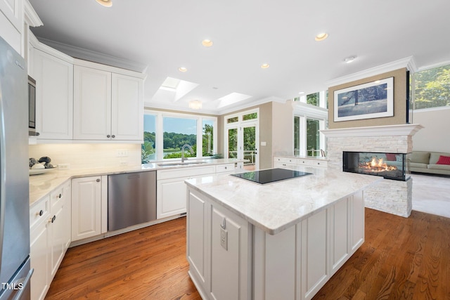 115 Loch Vale Ln, Cary, NC 27518 - kitchen featuring appliances with stainless steel finishes, a center island, crown molding, white cabinets, and wood finished floors