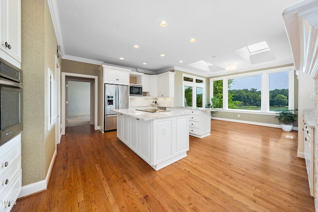 115 Loch Vale Ln, Cary, NC 27518 - kitchen featuring black appliances, a skylight, a center island, ornamental molding, and white cabinetry
