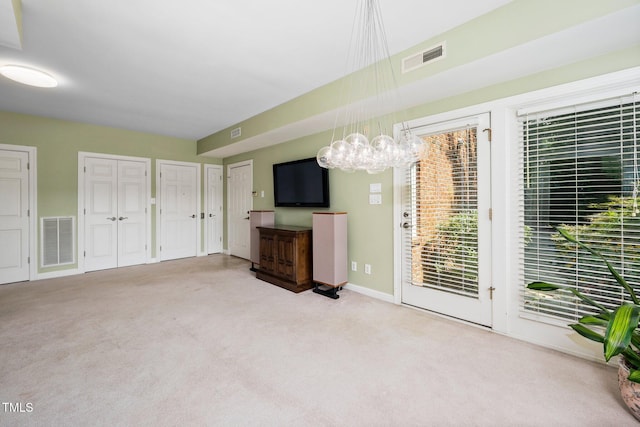 115 Loch Vale Ln, Cary, NC 27518 - unfurnished living room with carpet floors and a chandelier