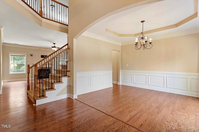 108 Holly Glen Ct, Holly Springs, NC 27540 - unfurnished dining area featuring wood finished floors, a ceiling fan, arched walkways, stairs, and a chandelier