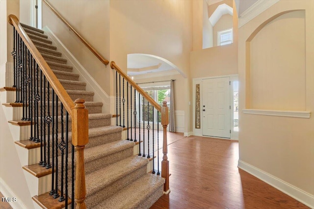 108 Holly Glen Ct, Holly Springs, NC 27540 - entrance foyer featuring arched walkways, wood finished floors, stairs, and a high ceiling