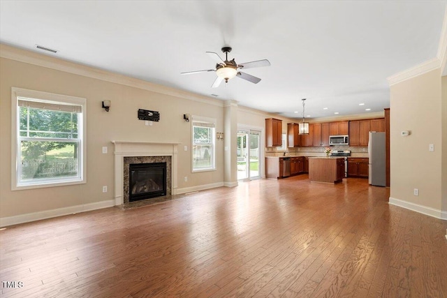 108 Holly Glen Ct, Holly Springs, NC 27540 - unfurnished living room with ceiling fan, light wood-style flooring, ornamental molding, a fireplace, and recessed lighting