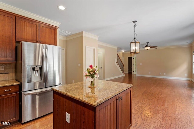 108 Holly Glen Ct, Holly Springs, NC 27540 - kitchen with stainless steel refrigerator with ice dispenser, a ceiling fan, light wood-style floors, a kitchen island, and ornamental molding