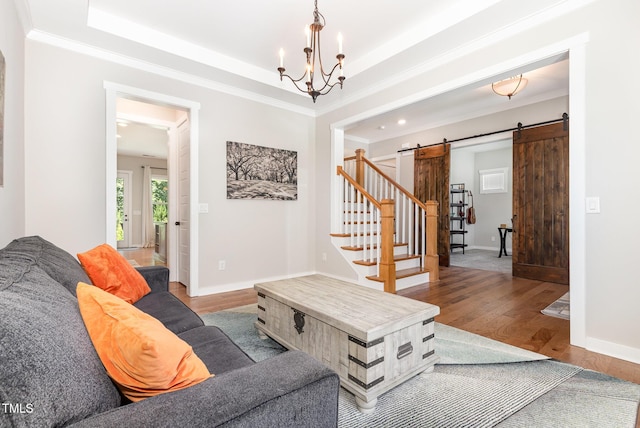 1502 Spring Overlook Ln, Hillsborough, NC 27278 - living area with a barn door, wood finished floors, a chandelier, ornamental molding, and a raised ceiling