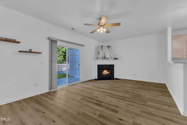 11309 Shadow Elms Ln, Raleigh, NC 27614 - unfurnished living room featuring a fireplace with flush hearth, wood finished floors, and a ceiling fan