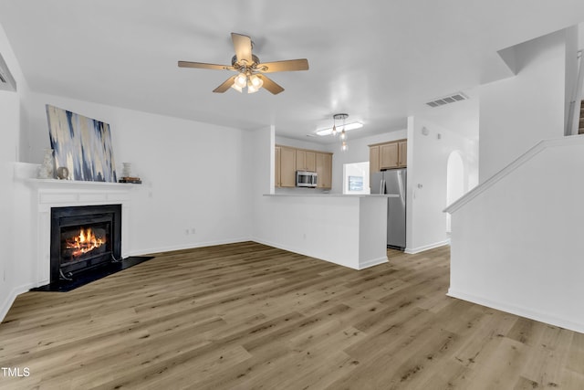 11309 Shadow Elms Ln, Raleigh, NC 27614 - unfurnished living room with a fireplace with flush hearth, light wood-type flooring, and a ceiling fan