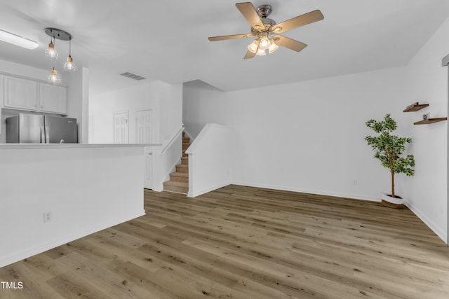 11309 Shadow Elms Ln, Raleigh, NC 27614 - unfurnished living room with light wood-style floors, stairway, and ceiling fan