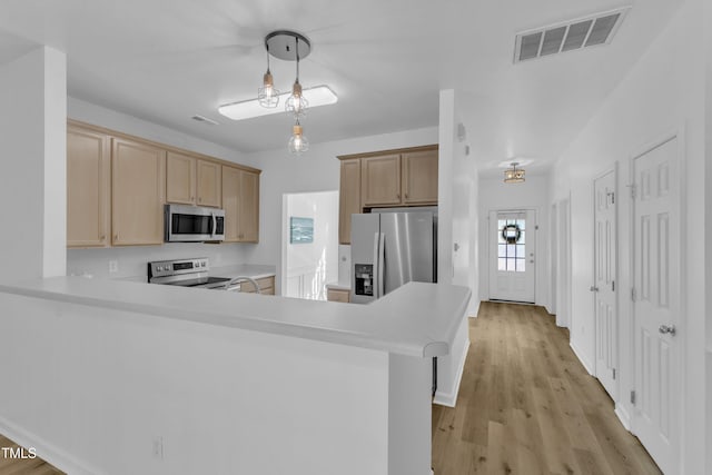 11309 Shadow Elms Ln, Raleigh, NC 27614 - kitchen featuring stainless steel appliances, a peninsula, light countertops, light wood-type flooring, and light brown cabinets