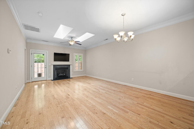 2022 Chandler Village Dr, Graham, NC 27253 - unfurnished living room with a fireplace with flush hearth, a skylight, light wood finished floors, ornamental molding, and a chandelier
