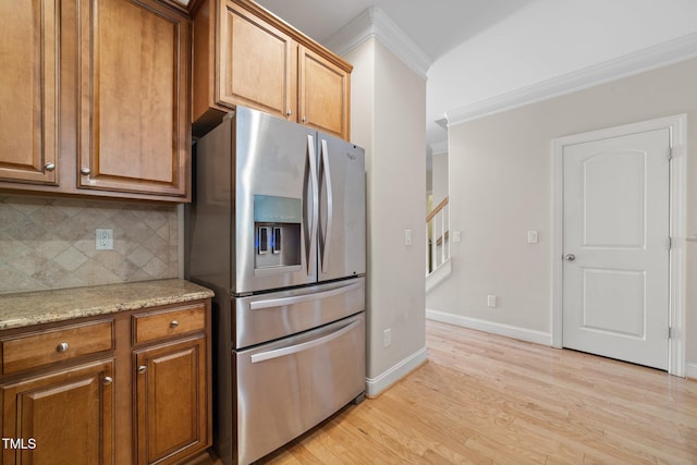 2022 Chandler Village Dr, Graham, NC 27253 - kitchen featuring stainless steel refrigerator with ice dispenser, ornamental molding, light wood-style flooring, decorative backsplash, and brown cabinetry