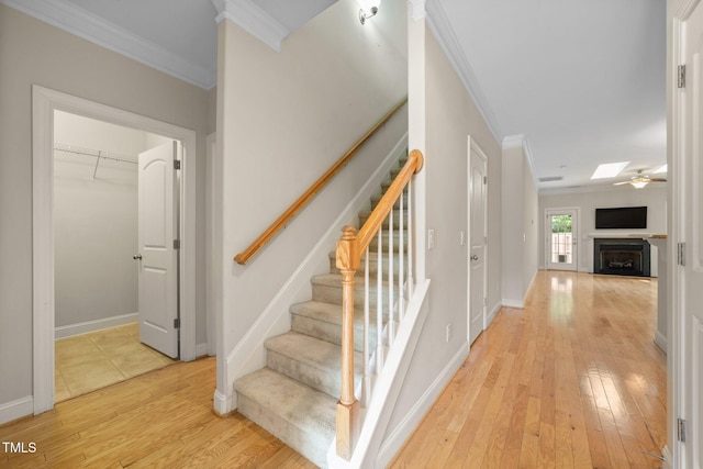 2022 Chandler Village Dr, Graham, NC 27253 - stairs featuring ornamental molding, a fireplace, wood-type flooring, and a skylight