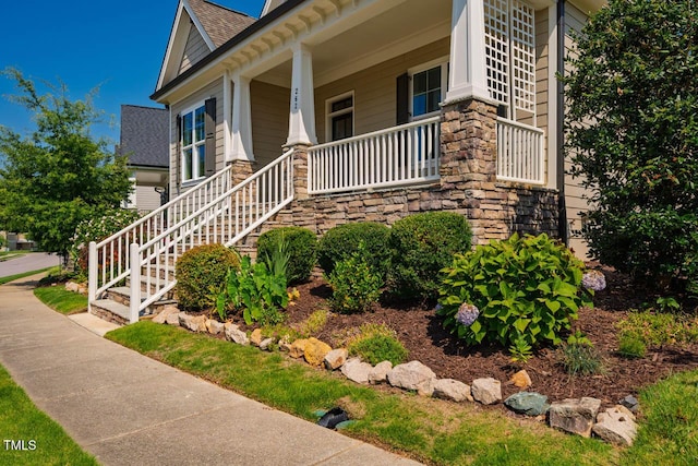 262 Salt Cedar Ln, Chapel Hill, NC 27516 - property entrance featuring covered porch, a shingled roof, and stone siding