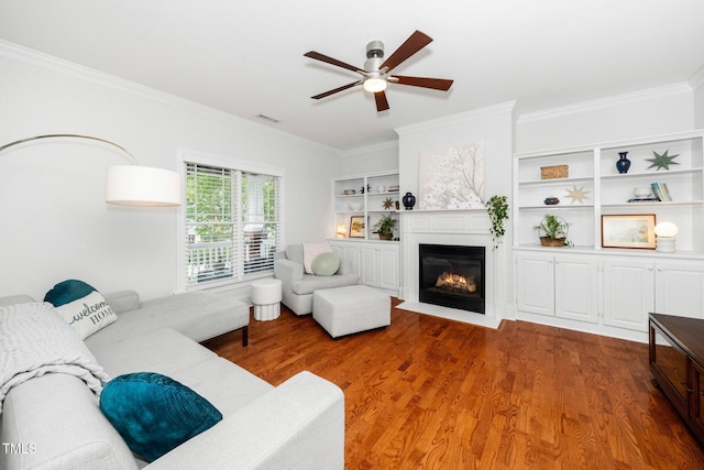 104 Homegate Cir, Apex, NC 27502 - living area with crown molding, wood finished floors, a ceiling fan, a fireplace with flush hearth, and built in features
